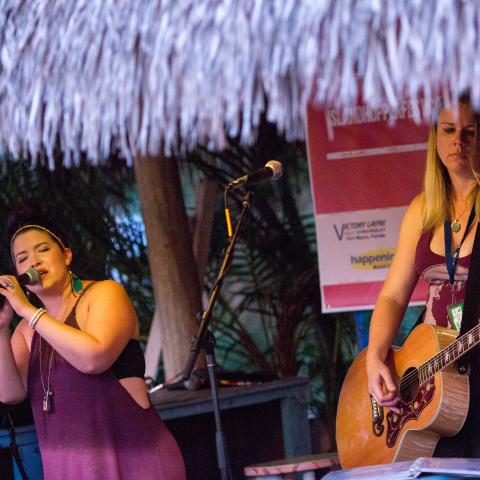 two woman band performing under tiki hut at island hopper fest