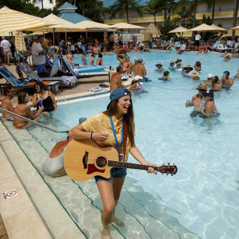 girl standing in pool with guitar